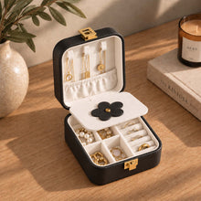 Charger l'image dans la galerie, Boite à bijoux de voyage fleur noire ouverte sur une commode

