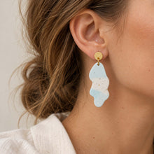 Charger l'image dans la galerie, Boucles d’oreilles en jesmonite terrazzo bleu portées à l’oreille
