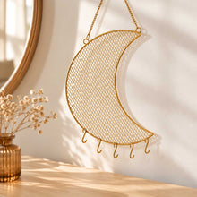 Charger l'image dans la galerie, Porte-bijoux mural lune en métal doré suspendu sur un mur beige, au-dessus d'une commode en bois
