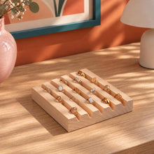 Charger l'image dans la galerie, Présentoir à bagues en bois naturel garni de bagues dorées sur une commode
